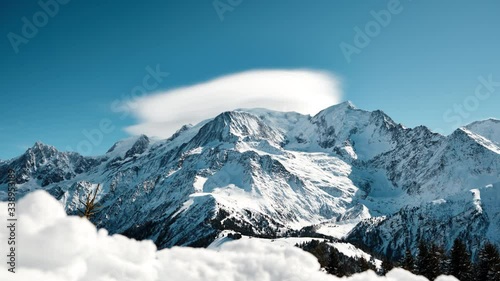 Mountain time-lapse with adiabatically cooled clouds formed at the peak in the picturesque French Alps photo