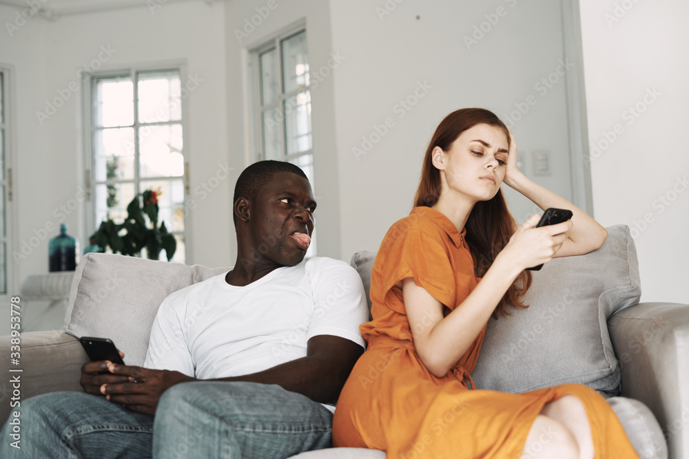 Man and woman at home with a phone in their hands communicating discontent resentment