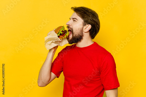 A man eating a hamburger fast food restaurant gourmet meal