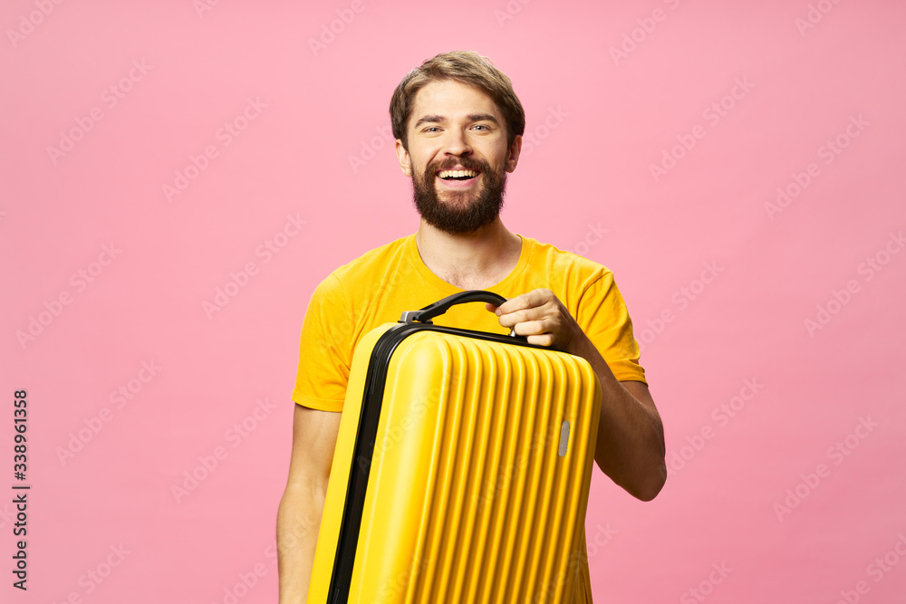 Cheerful man suitcase on vacation travel passenger pink background