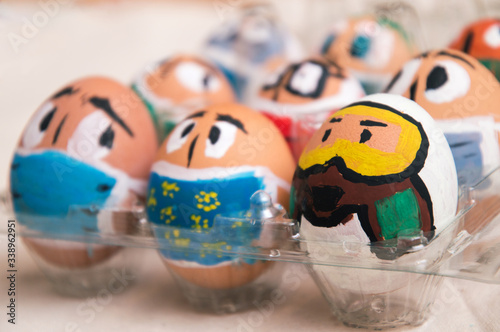 Concept. Easter during coronavirus. Easter eggs painted as faces with medical masks, respirators.