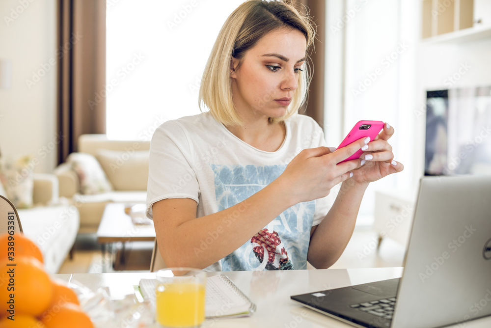 Young woman working from home at kitchen table. Young woman working from home at kitchen table.