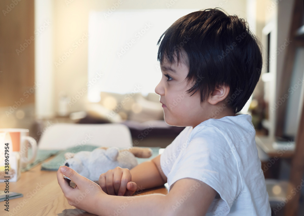 kid self isolation playing a game of cards in living room with bright light in morning,Child boy playing counting card game, Family indoor activity at home. Home schooling,Social Distancing kid self isolation playing a game of cards in living room with bright light in morning,Child boy playing counting card game, Family indoor activity at home. Home schooling,Social Distancing