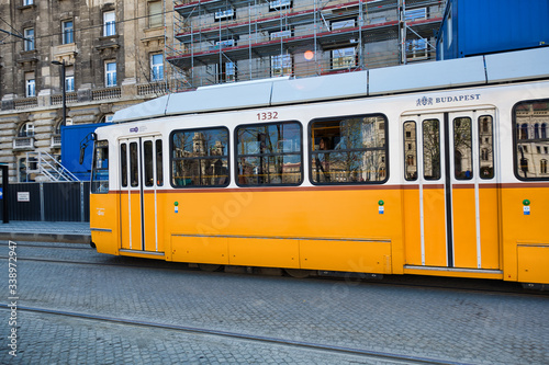 BUDAPEST, HUNGARY - MARCH 30, 2019: Old yellow tram speeds up along city streets. The historical center of the capital of Hungary