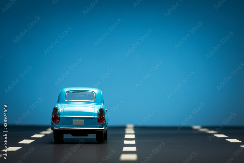 Rear view of a Blue toy car on a blue background.