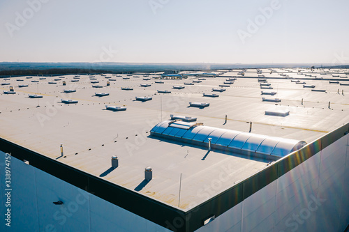 Large roof of factory with roof ventilators, drone shot from above