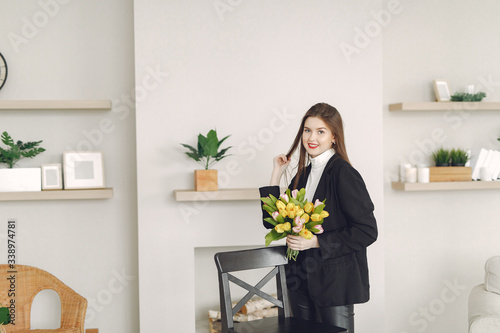 Beautiful girl at home. Lady with bouquet of tulip. Mother's day.