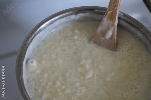Cooking of rice porridge on oven, the first stage of preparation of national Finnish dish from rye flour and rice - Karelian pies