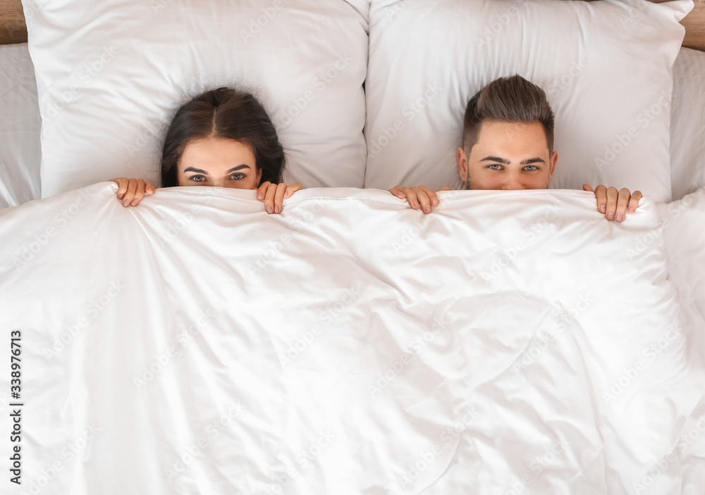 Young couple lying in bed at home Young couple lying in bed at home