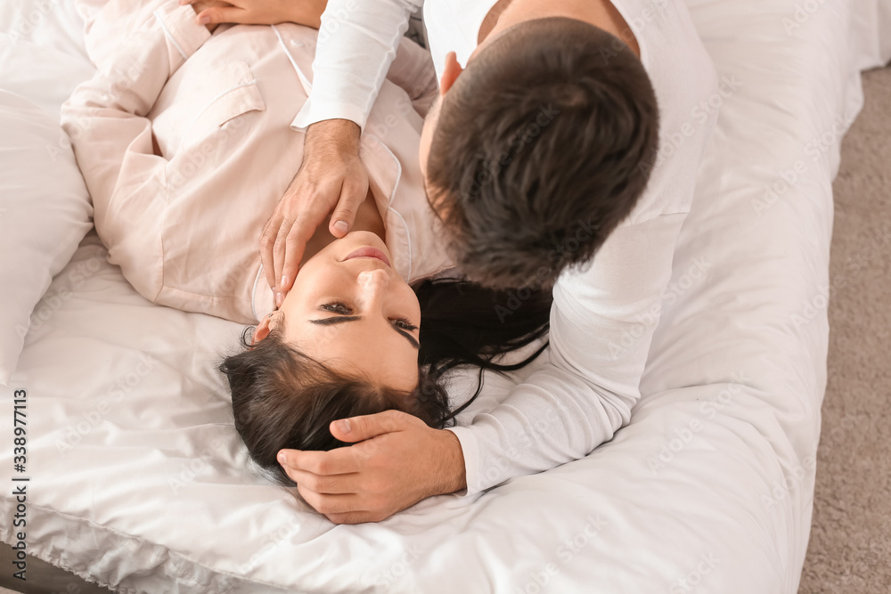Happy young couple lying in bed at home Happy young couple lying in bed at home