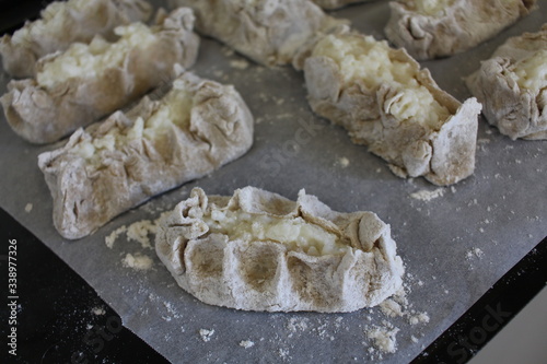 Cooked Karelian pies - Pirakka on a baking sheet. Dish of national cuisine - piirakka. Close-up. photo