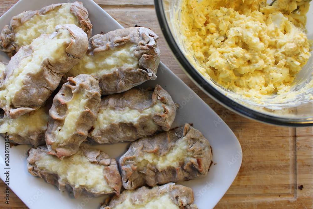 Cooked Karelian pies - Pirakka on a baking sheet. Dish of national cuisine - piirakka. Close-up. Cooked Karelian pies - Pirakka on a baking sheet. Dish of national cuisine - piirakka. Close-up.