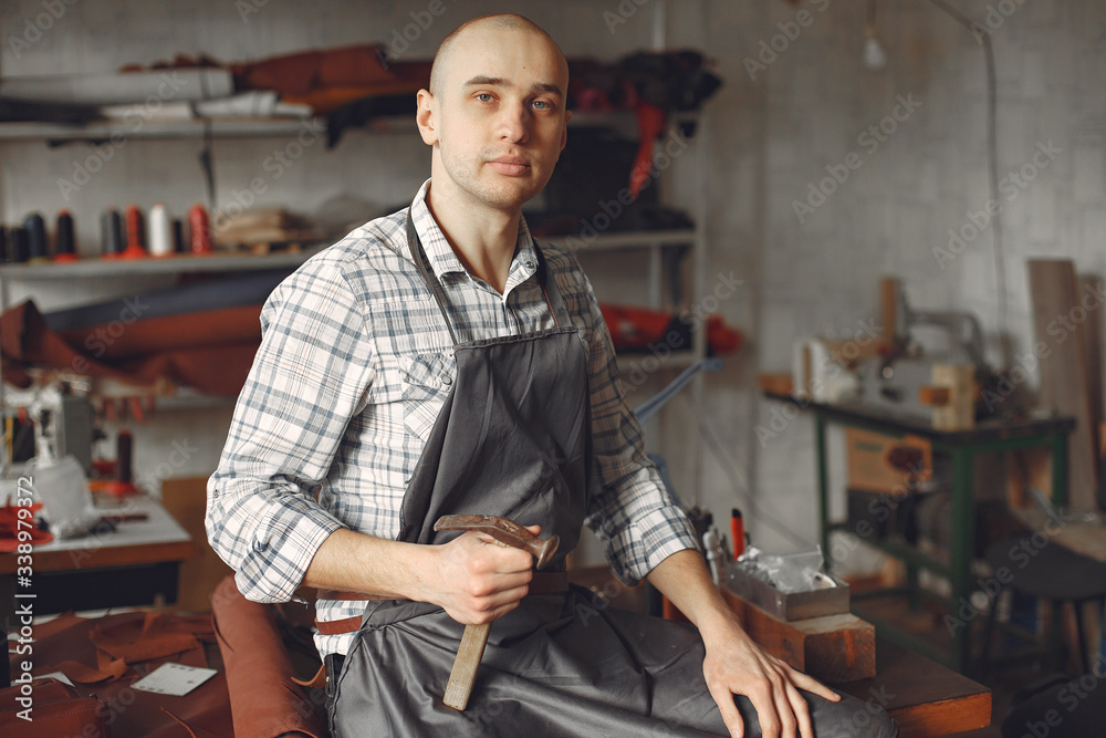 Man working with leather. Professional makes a belts.