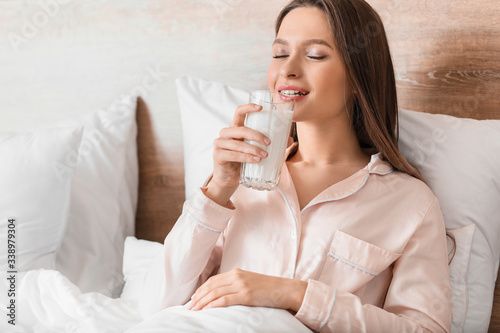 Canvastavla Young woman drinking milk in bedroom