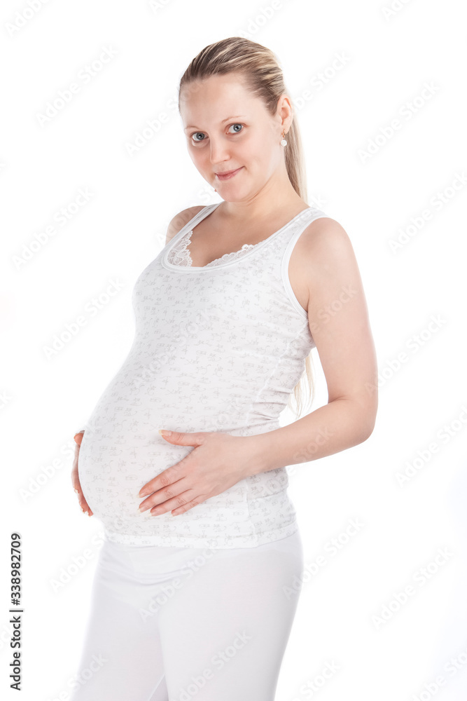 Happy Pregnant Caucasian Woman Standing In White Shirt And Pants Against Pure White Background. Happy Pregnant Caucasian Woman Standing In White Shirt And Pants Against Pure White Background.