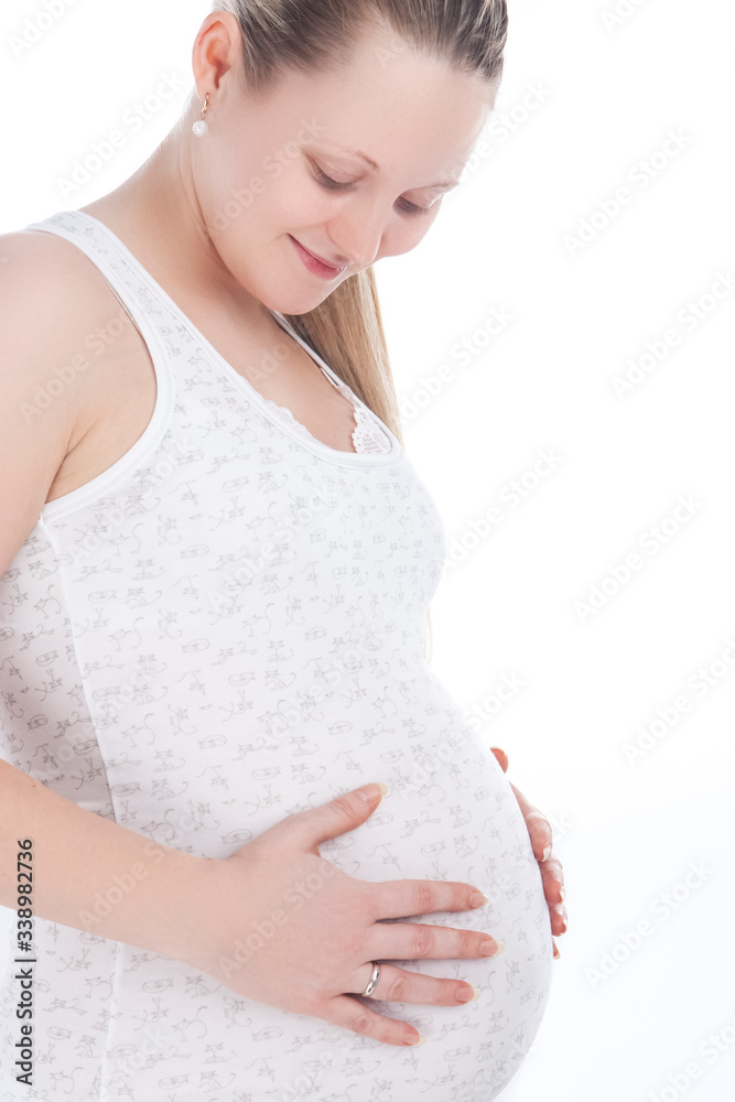 Closeup Portrait of Happy Pregnant Caucasian Woman Standing In White Shirt And Pants Against Pure White Background. Closeup Portrait of Happy Pregnant Caucasian Woman Standing In White Shirt And Pants Against Pure White Background.