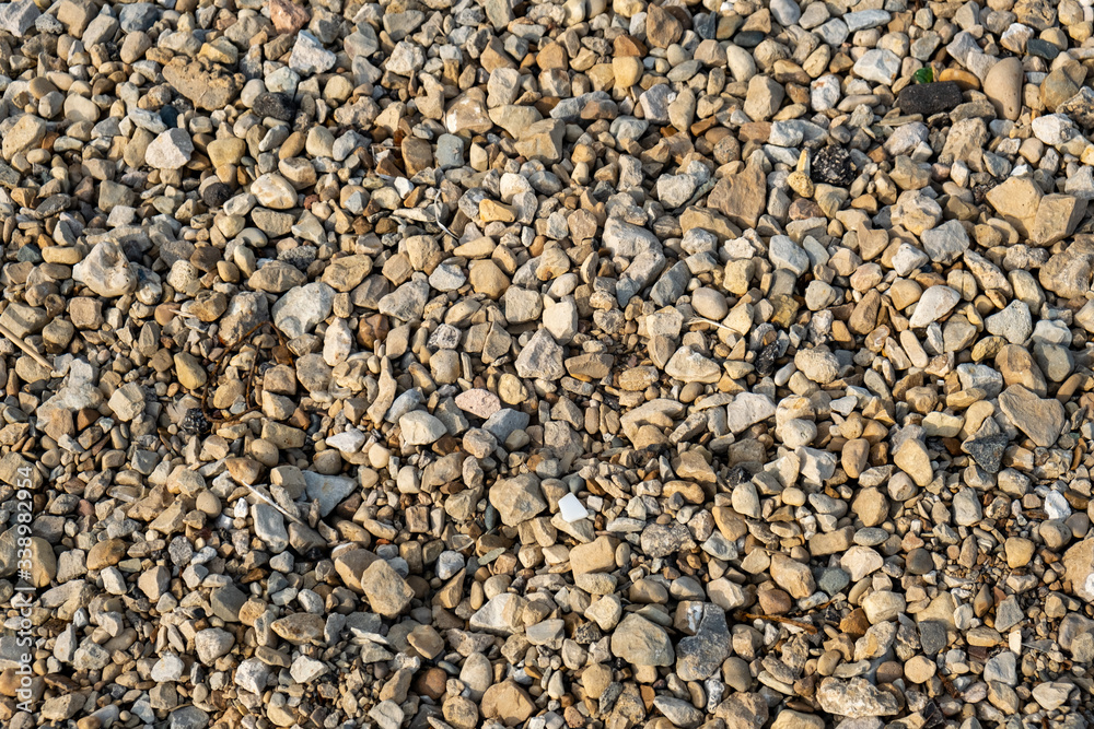 Top down shot of a colorful background texture of stones and pebbles on a beach Top down shot of a colorful background texture of stones and pebbles on a beach