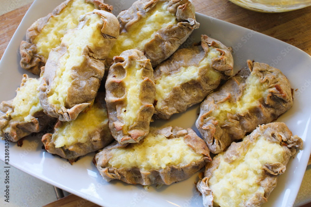 Cooked Karelian pies - Pirakka on a baking sheet. Dish of national cuisine - piirakka. Close-up. Cooked Karelian pies - Pirakka on a baking sheet. Dish of national cuisine - piirakka. Close-up.