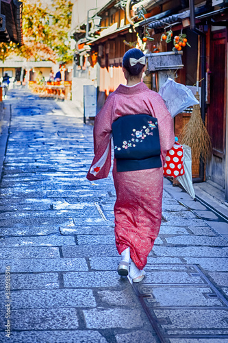 Kyoto Traveling. Geisha in Traditional Japanese Kimono and Rucksack Posing on Famous Gion Street in Kyoto City,  Japan. photo