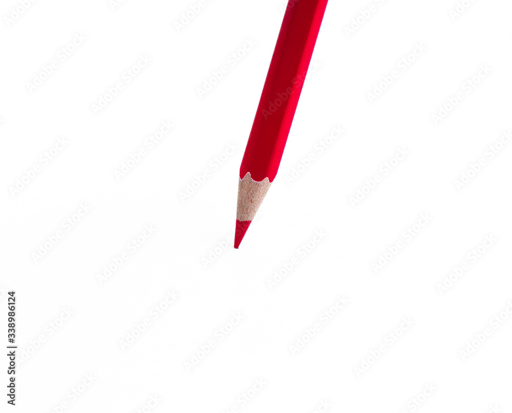 Portrait of one single red colored wood pencil crayon placed on an isolated white background
