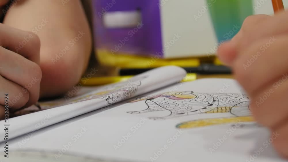 Hands of children of close up. Children drawing coloring picture with pencils and felt-tip pens.