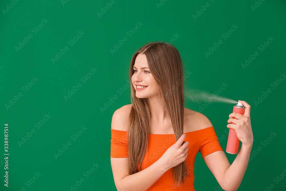 Beautiful young woman with hair spray on color background Beautiful young woman with hair spray on color background