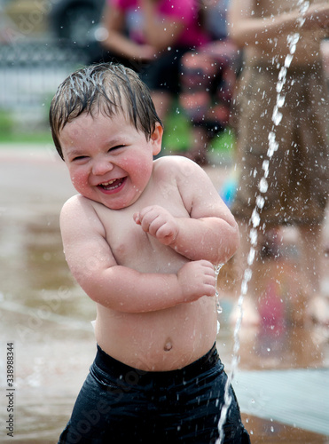 Принти на полотні adorable little boy  laughs as he is playing in an urban fountain