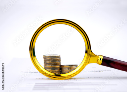 Magnifying glass and coins