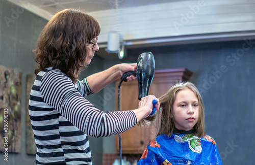 Young girl has her hair styled at a beauty shop