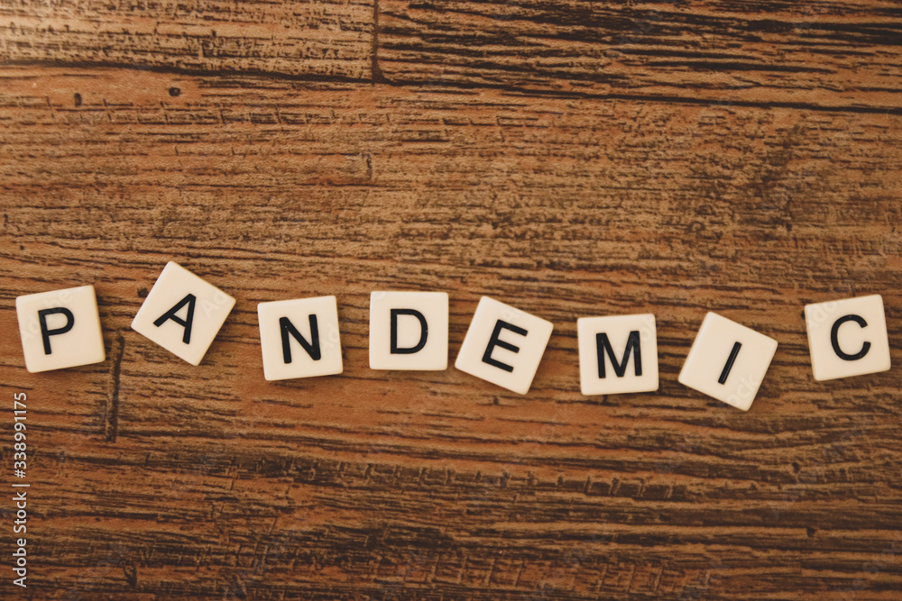 Naklejka premium The word pandemic scattered about with tiled letters 