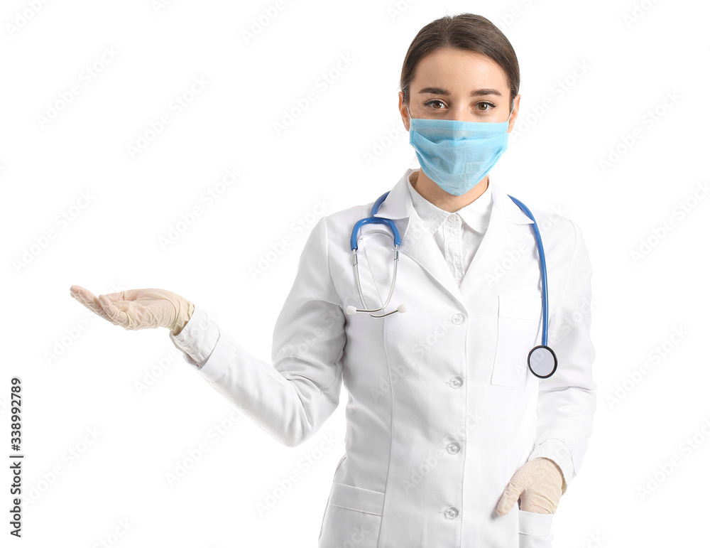 Doctor in medical mask showing something against white background Doctor in medical mask showing something against white background