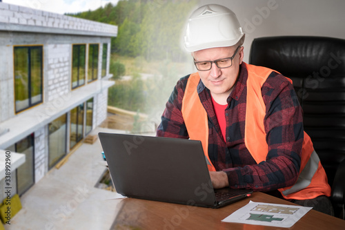 Engineer at a laptop against the background of a stone building