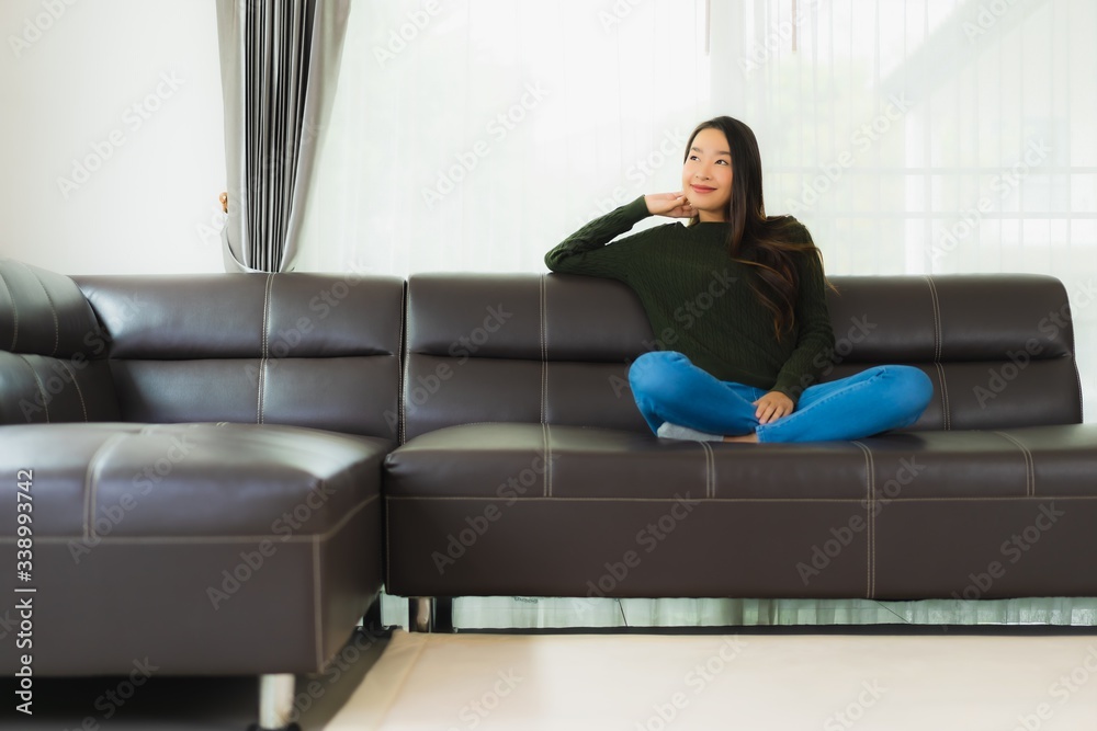 Beautiful portrait young asian woman sit relax on sofa