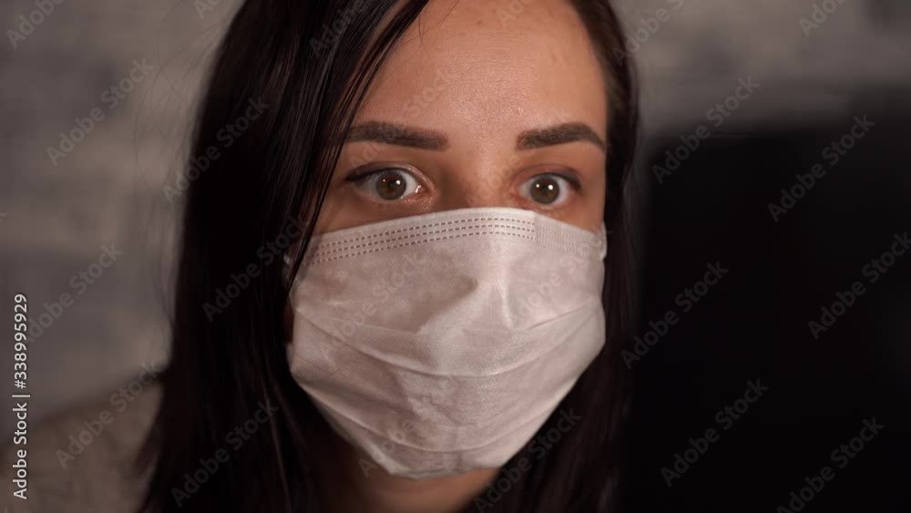 A woman in a medical mask learns news about the coronavirus from the Internet using a laptop. Female is concerned about his health. The Epidemic Of Coronavirus. A woman in a medical mask learns news about the coronavirus from the Internet using a laptop. Female is concerned about his health. The Epidemic Of Coronavirus.