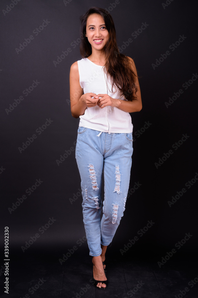 Young beautiful Asian woman against black background Young beautiful Asian woman against black background
