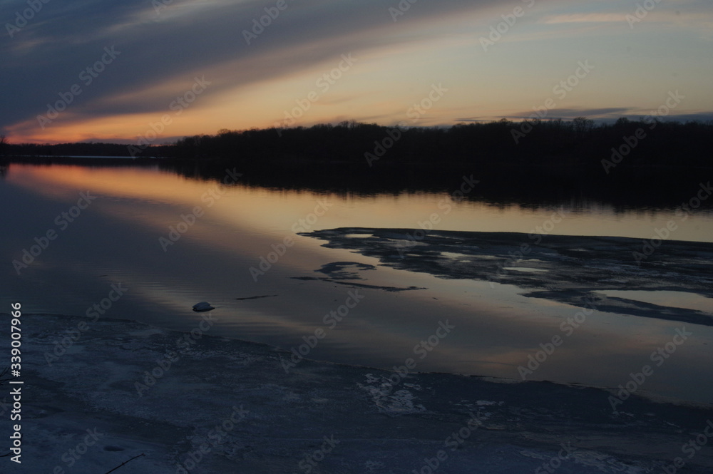 sunset over ice thaw on lake