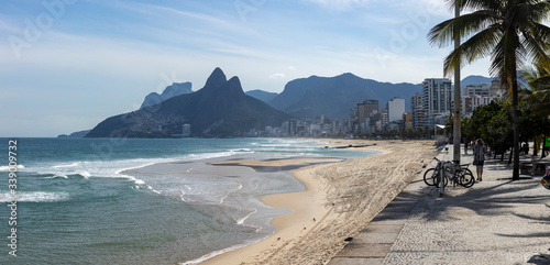 Almost empty Ipanema beach and boulevard with the Two Brothers mountain in the background during the COVID-19 outbreak in Rio de Janeiro after a tidal wave that damaged the beach [Date April 14, 2020]
