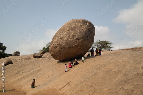 Foto People By Huge Rock On Arid Landscape Against Sky