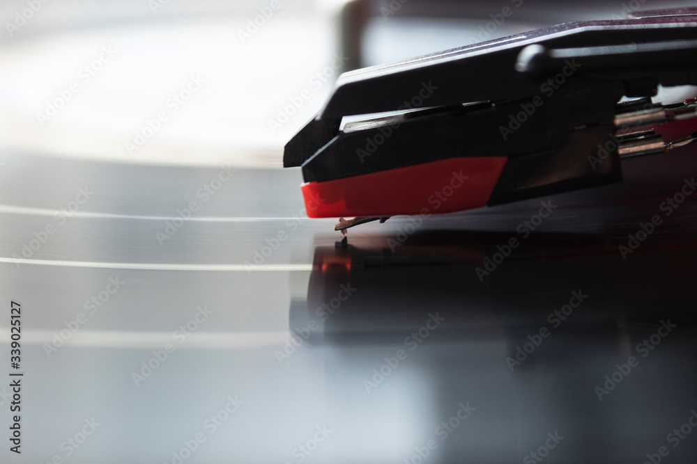 macro photograhpy to a red turntable needle and LP vinyl playing music. macro photograhpy to a red turntable needle and LP vinyl playing music.