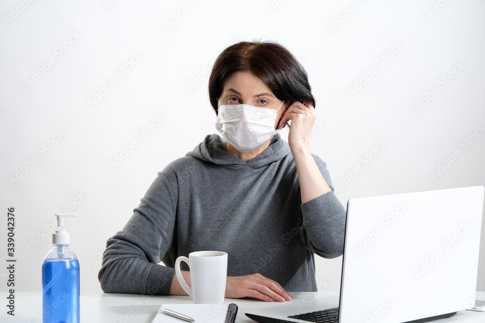 woman with laptop. Elderly woman in a protective mask at the desk. woman with laptop. Elderly woman in a protective mask at the desk.