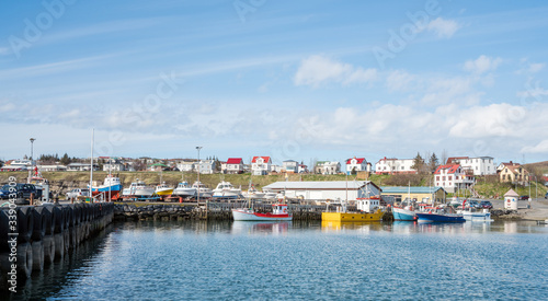 The charming city and the fishing harbour of Husavik in the northern part of Iceland. Photographed from sea during sunny day in spring.