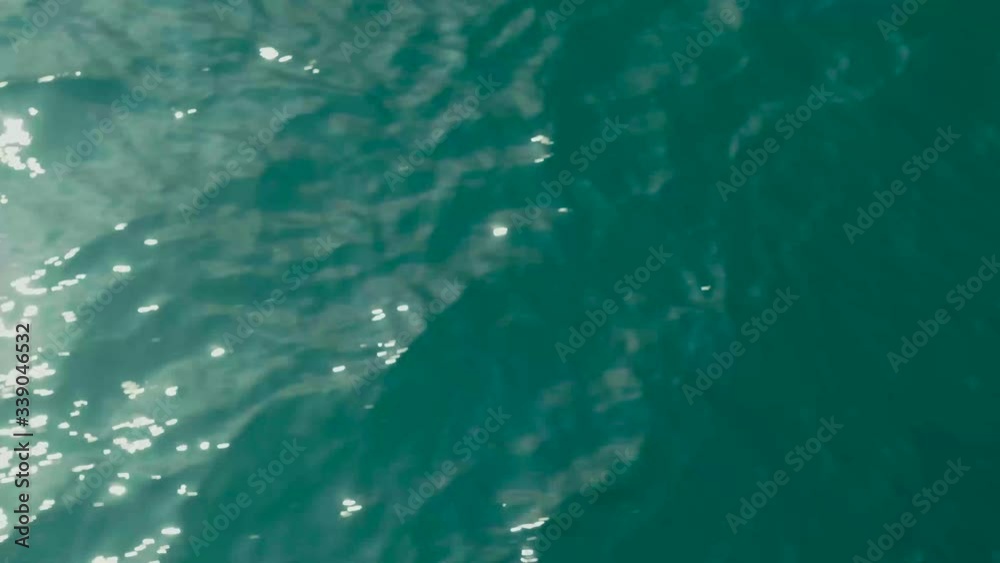 Aerial top down view from high altitude of green sea water texture. The camera flies over the water, a view of the water surface. Background of the water surface. 4K aerial view Aerial top down view from high altitude of green sea water texture. The camera flies over the water, a view of the water surface. Background of the water surface. 4K aerial view