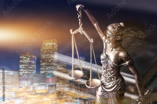 Lady Themis with scales of justice on the city background