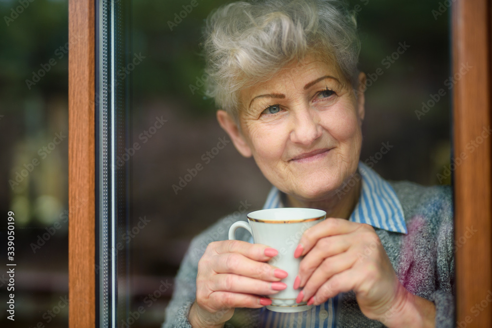 Sad senior woman with coffee indoors at home, corona virus and quarantine concept. Sad senior woman with coffee indoors at home, corona virus and quarantine concept.