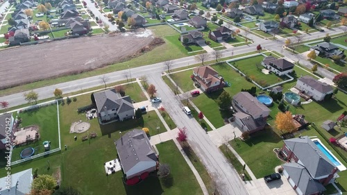Overhead aerial view of colorful autumn trees residential houses and yards along suburban street - Travel and leisure concept