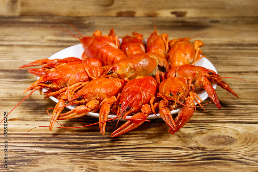 Boiled crayfish in plate on wooden table Boiled crayfish in plate on wooden table