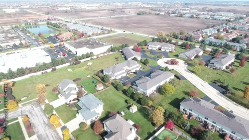 Overhead aerial view of colorful autumn trees residential houses and yards along suburban street - Travel and leisure concept
