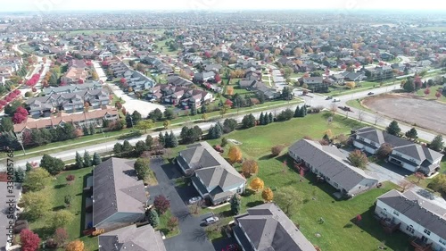 Overhead aerial view of colorful autumn trees residential houses and yards along suburban street - Travel and leisure concept