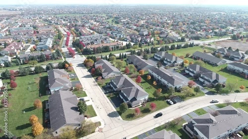 Overhead aerial view of colorful autumn trees residential houses and yards along suburban street - Travel and leisure concept