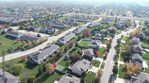 Overhead aerial view of colorful autumn trees residential houses and yards along suburban street - Travel and leisure concept